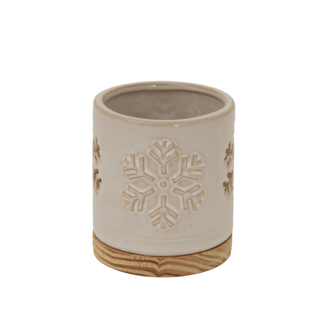 Cream cylindrical candle holder with a snowflake motif facing forward and a round grain-patterned base.