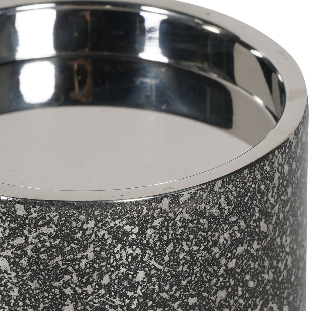 Close-up of the candle holder's polished rim and reflective interior above the etched outer surface.