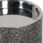 Close-up of the candle holder's polished rim and reflective interior above the etched outer surface.