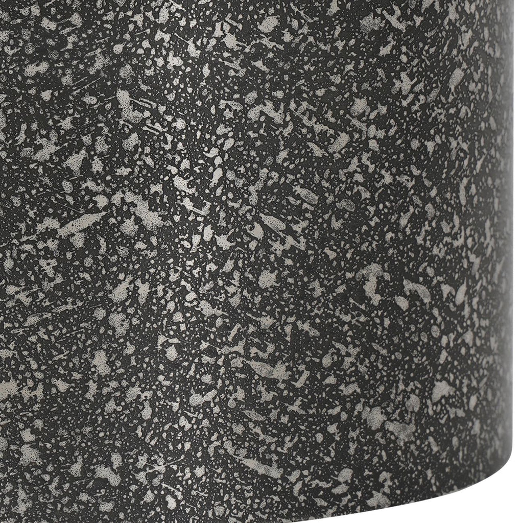 Close-up of the candle holder's mottled dark and silver etched texture and curved lower edge.