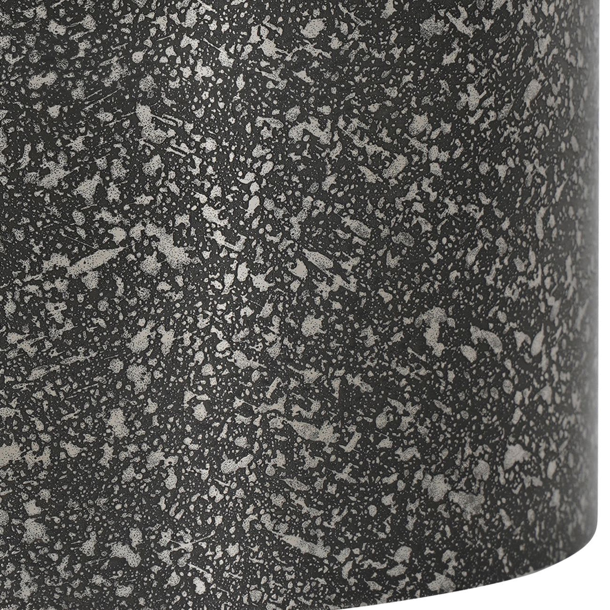 Close-up of the candle holder's mottled dark and silver etched texture and curved lower edge.
