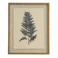 Front view of a portrait fern print, with a single dark frond on a pale ground inside a broad textured surround and tan-gold beaded frame.