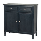 Dark charcoal-black sideboard viewed from the front and right, showing two drawers, two panelled doors, pale round knobs and short turned-profile feet.
