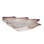 Low angled view of the shallow tree-shaped dish, showing its raised branch-shaped sides, pale exterior and warm tan edge.