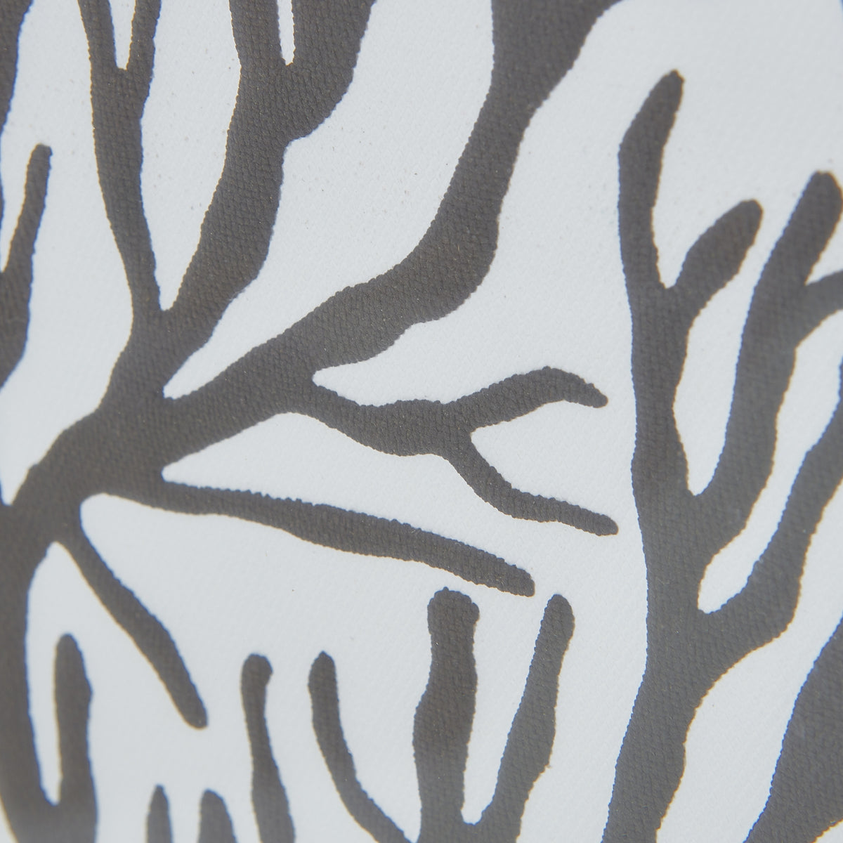 Close-up of dark-grey branching shapes against a pale ground, revealing the graphic's irregular edges and fine surface texture.