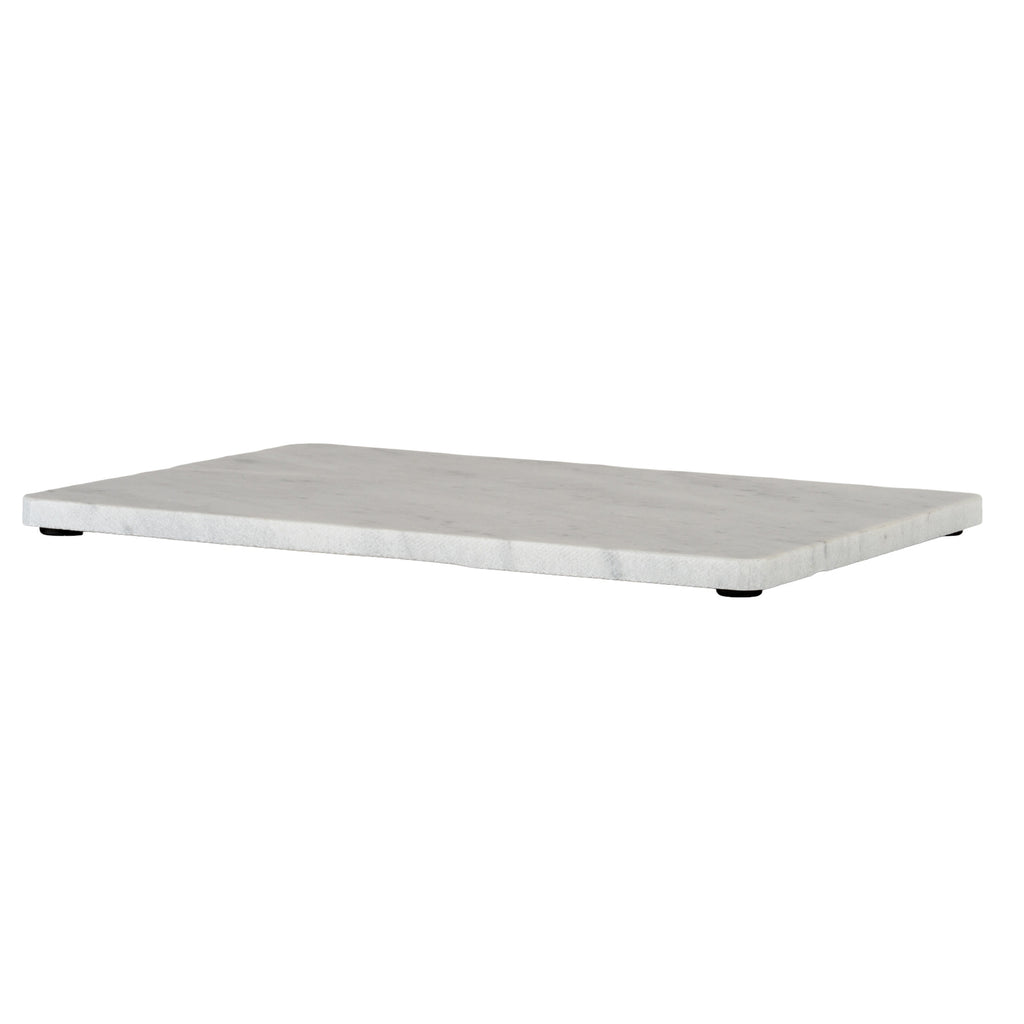 Low angled view of the serving board showing its thin pale edge, lightly marbled top and black pads beneath.