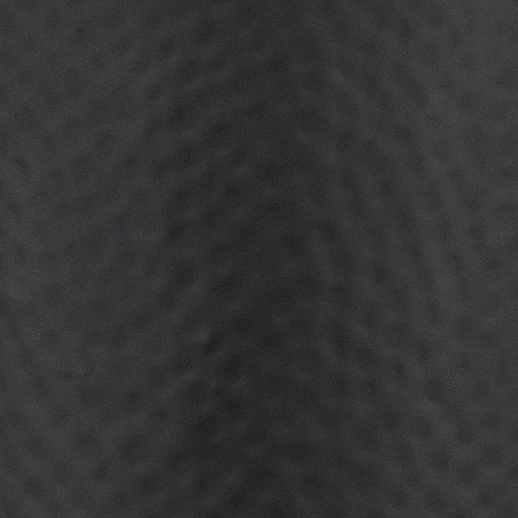 Close-up of the charcoal-black surface, showing shallow dimples and the softly matt-looking finish.