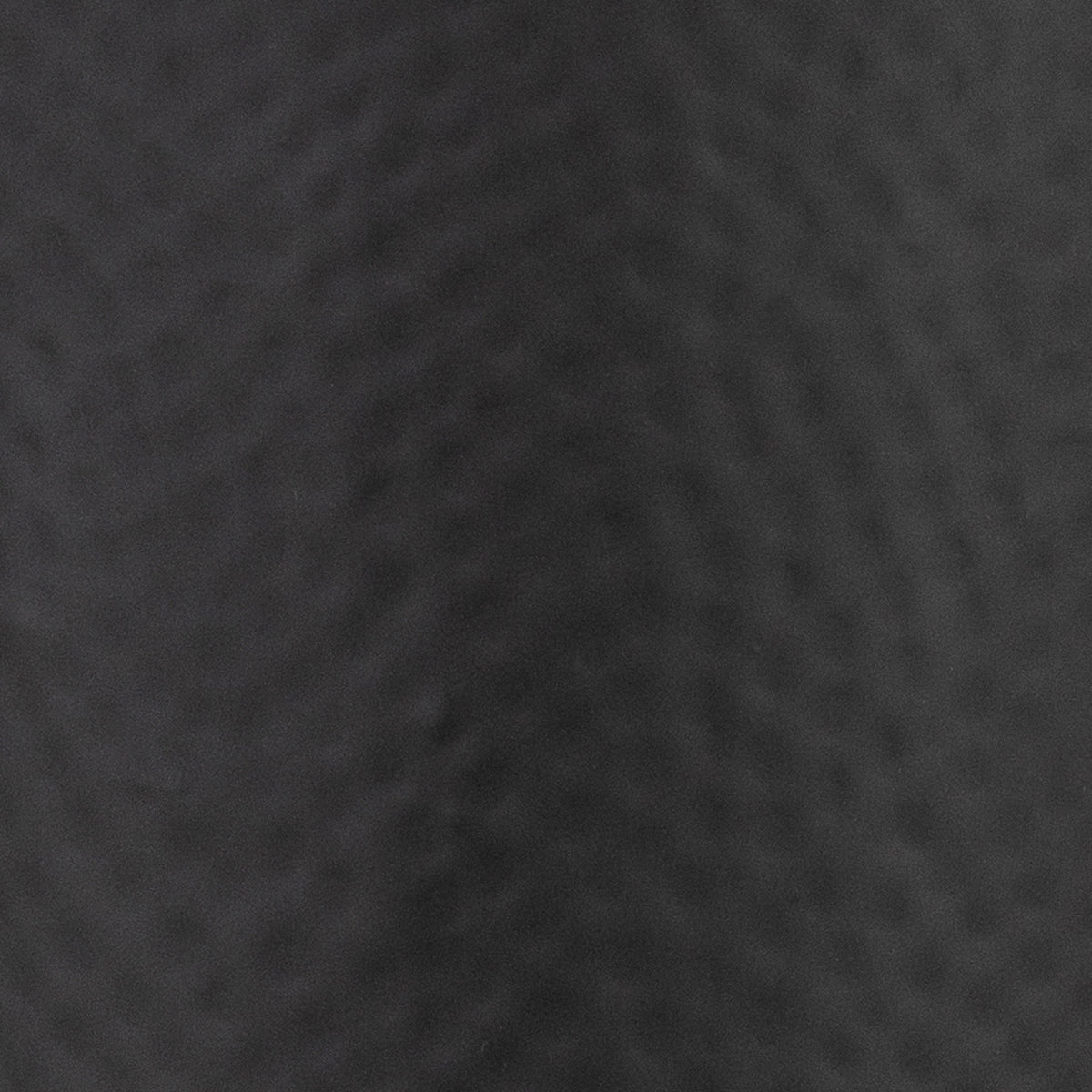 Close-up of the charcoal-black surface, showing shallow dimples and the softly matt-looking finish.