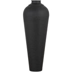 Front view of a tall matt-black vase with a tapered body, rounded shoulders, dimpled surface and flat circular cap on a white background.