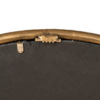 Rear detail of the mirror showing dark backing, a gold-tone edge and a small toothed hanging fitting.