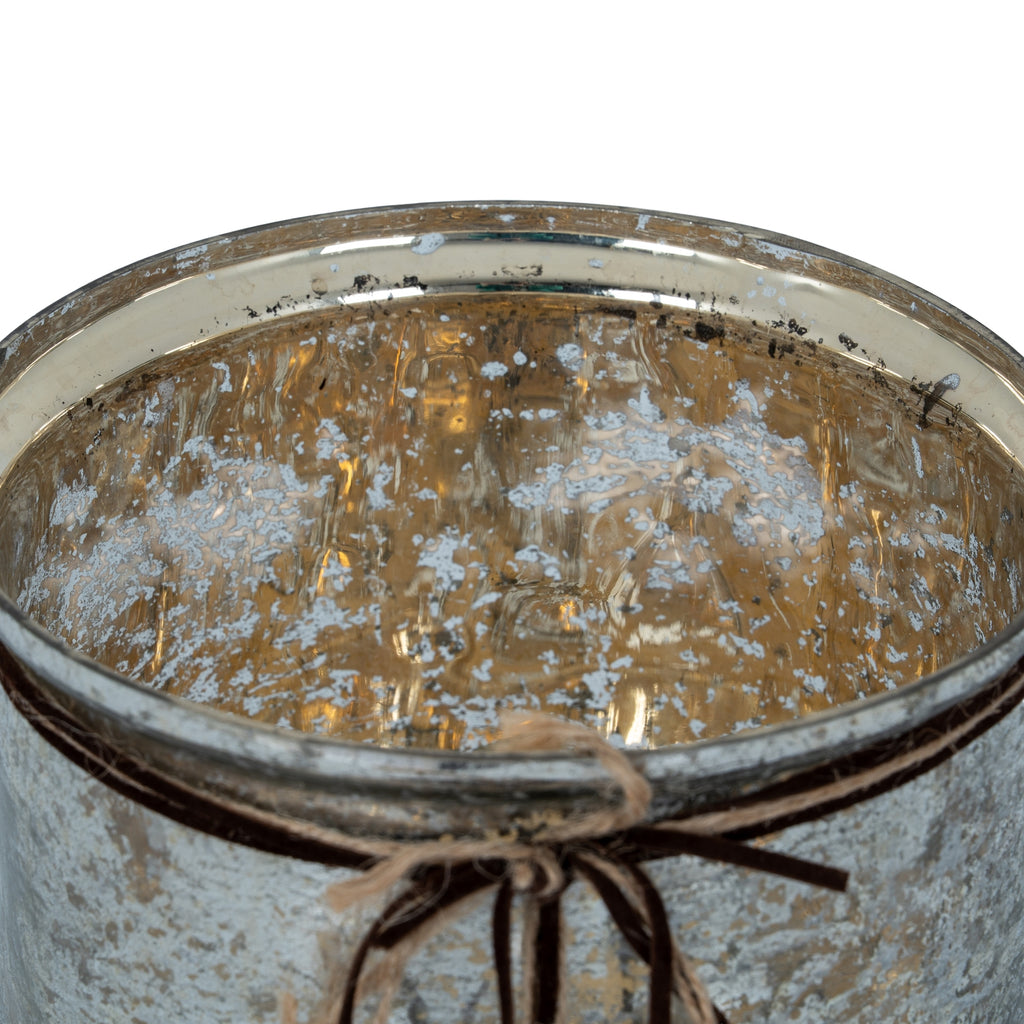 View into the candle holder's empty open rim, showing the reflective gold-toned interior with irregular pale mottling.