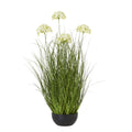 Full view of the artificial arrangement with tall green blades, pale domed flower heads at varied heights and a rounded black pot.
