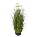 Full view of the artificial arrangement, with tall green blades and pale domed flower heads rising from a low rounded black pot.
