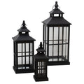 Three graduated black lanterns on a white background, with the tallest at the back right, a medium lantern at the left and the smallest in front; each has clear crossbarred panels, a double roof, a tiered finial and a loop handle.