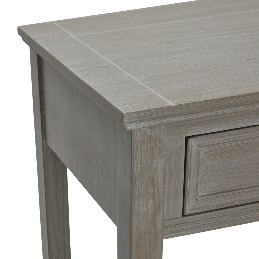 Angled detail of the console's top corner, showing the pale streaks in the grey finish, projecting top edge and framed drawer front.