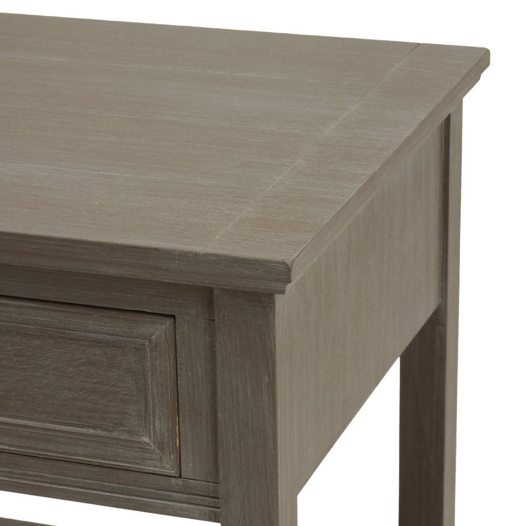 Detail of the table's projecting top edge, grey-washed side panel and framed drawer corner.