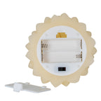 Underside of the cream tree-shaped candle showing an open two-cell battery compartment, spring contacts and a black slide switch, with the detached cover beside it.