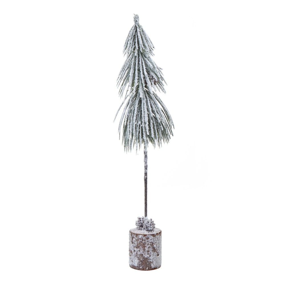 Full view of a narrow snow-effect tree decoration with drooping green fronds, a long dark trunk and cones on a cylindrical log-style base.