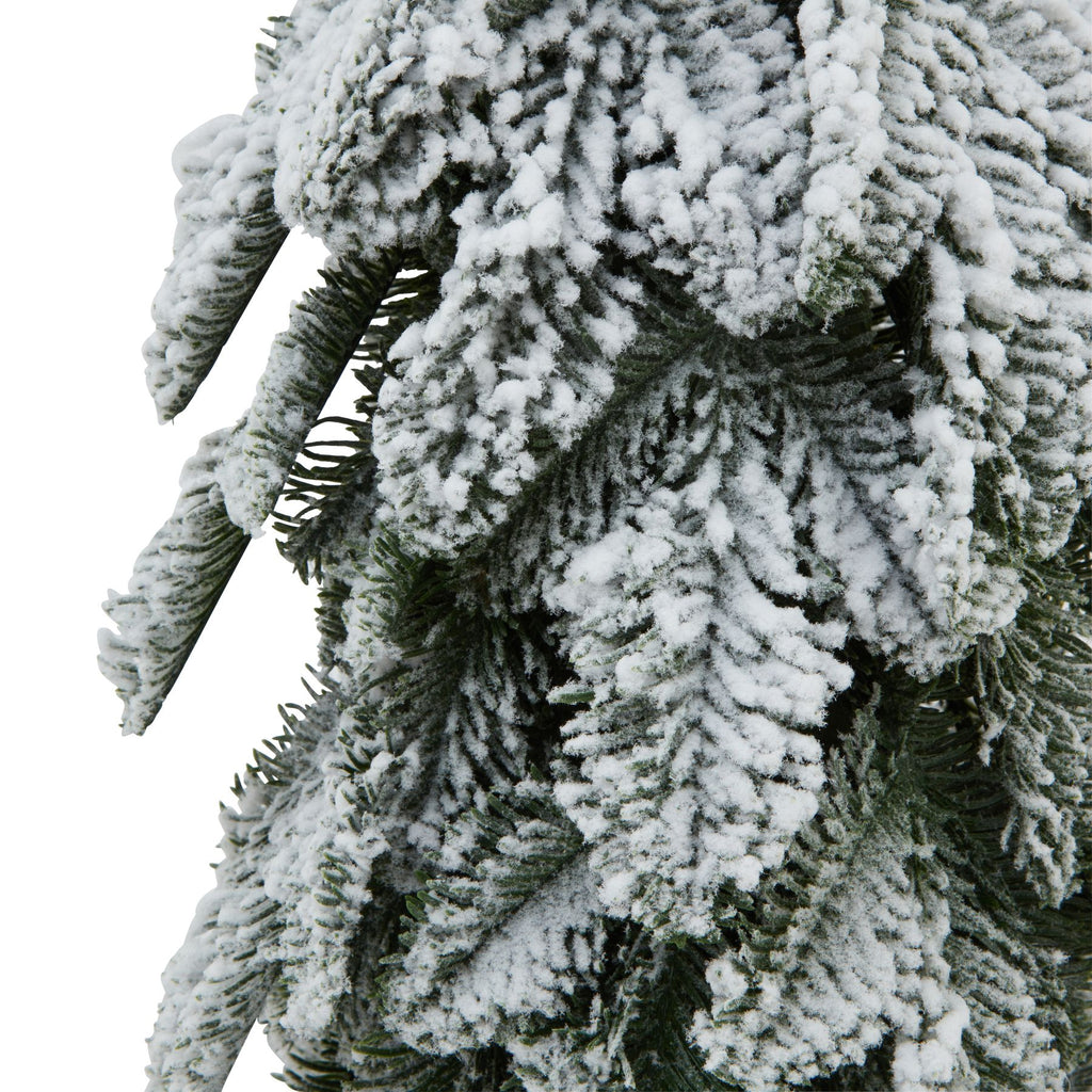 Close-up of overlapping needle-like green branch sprays with thick, irregular patches of white snow-effect coating.