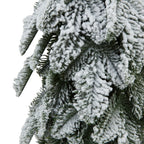 Close-up of overlapping needle-like green branch sprays with thick, irregular patches of white snow-effect coating.