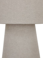Tight detail of the shade meeting the tapered base, showing fine threads and tonal variation in the natural-coloured linen.