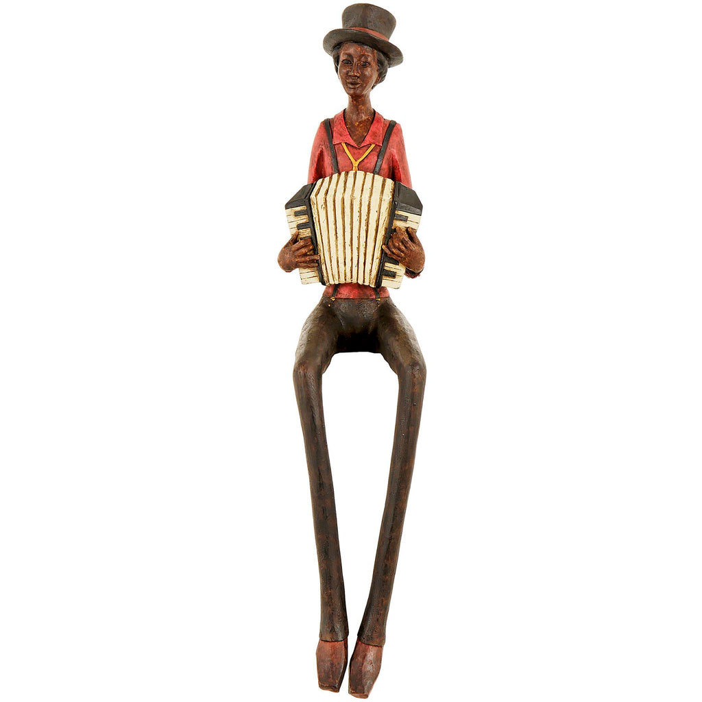 Full front view of a seated accordion musician figurine wearing a tall dark hat and red shirt, with long dangling legs and pointed shoes.