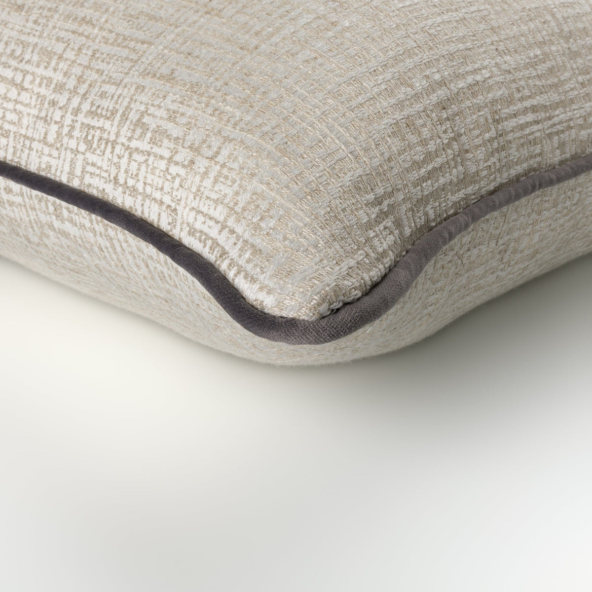 Close-up of the Elara Cushion showing its neutral geometric weave and angelite piping