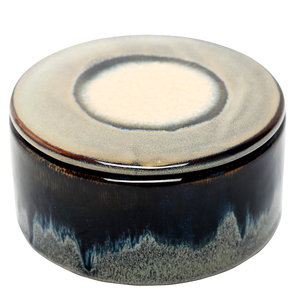 Elevated view of the closed candle, showing the lid's cream centre, grey ring and dark brown rim.