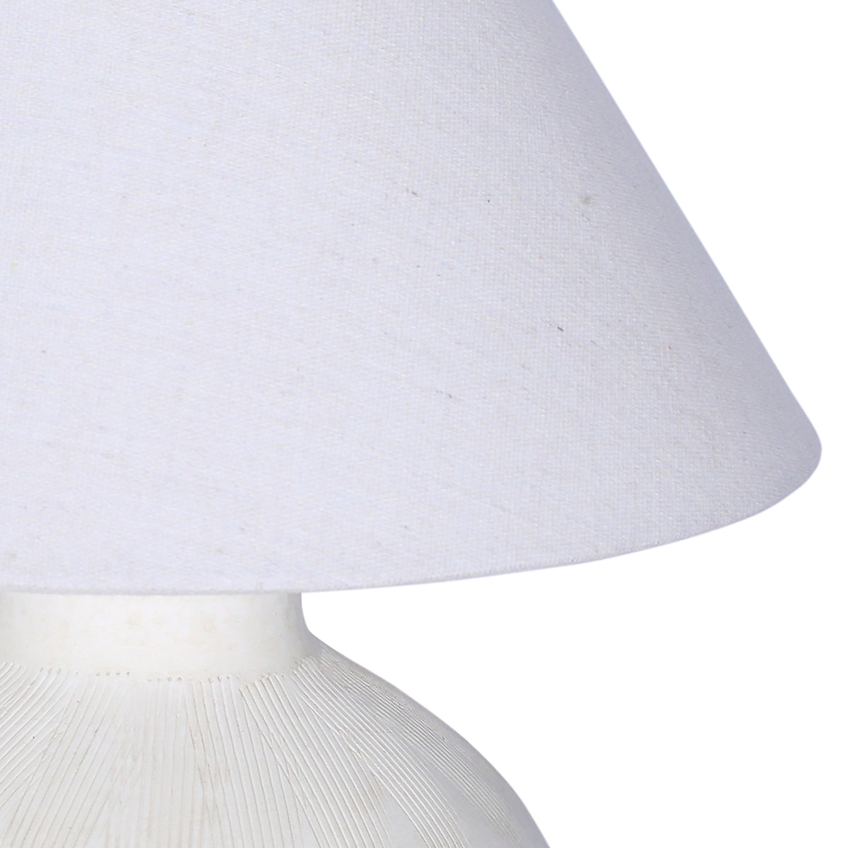 Detail of the pale woven fabric shade and the fine lines etched around the ceramic shoulder below it.