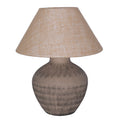 Brown table lamp with a rounded etched ceramic base and wide, tapered beige hessian shade on a white background.