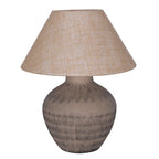 Brown table lamp with a rounded etched ceramic base and wide, tapered beige hessian shade on a white background.
