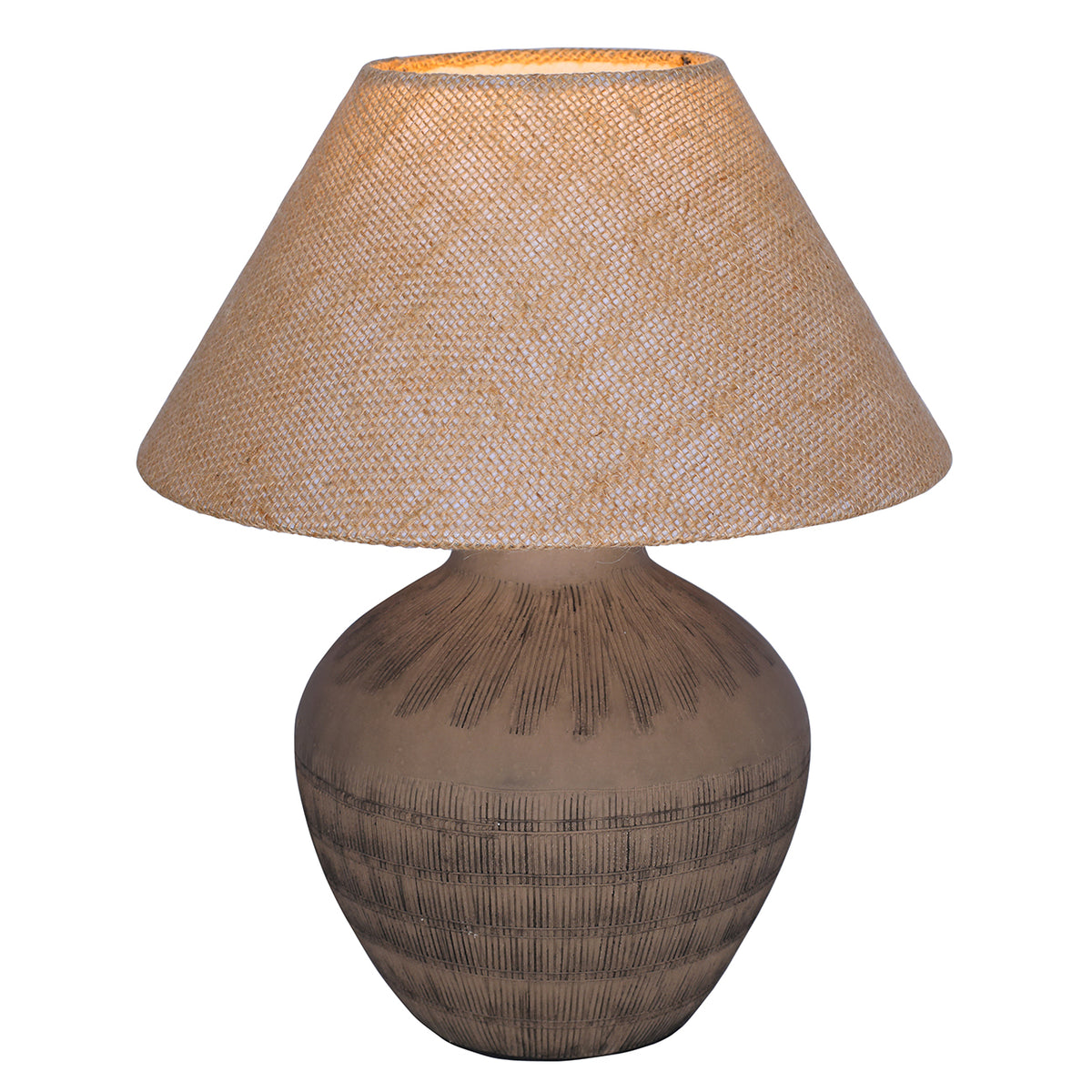 Table lamp switched on, with a warm glow visible through the woven hessian shade above the brown etched base.