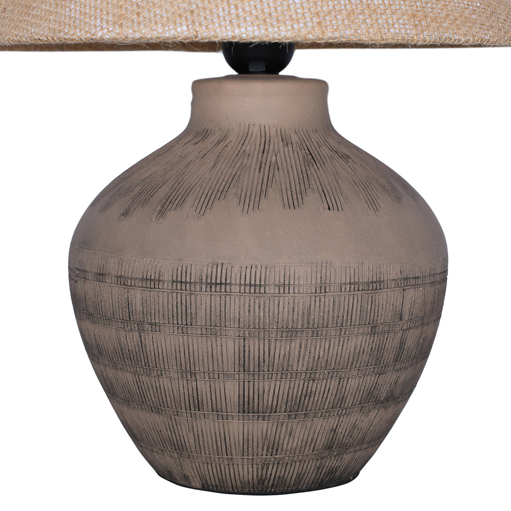 Close view of the rounded ceramic lamp base, showing radiating etched lines at the shoulder and horizontal bands below.