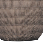 Detail of dark vertical etched strokes divided by horizontal bands across the lower brown ceramic lamp base.