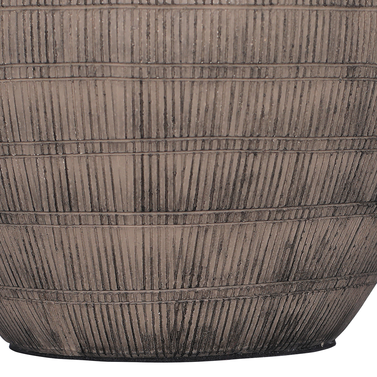 Detail of dark vertical etched strokes divided by horizontal bands across the lower brown ceramic lamp base.
