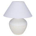 White table lamp with a rounded etched ceramic base and a broad tapered fabric shade against a white background.