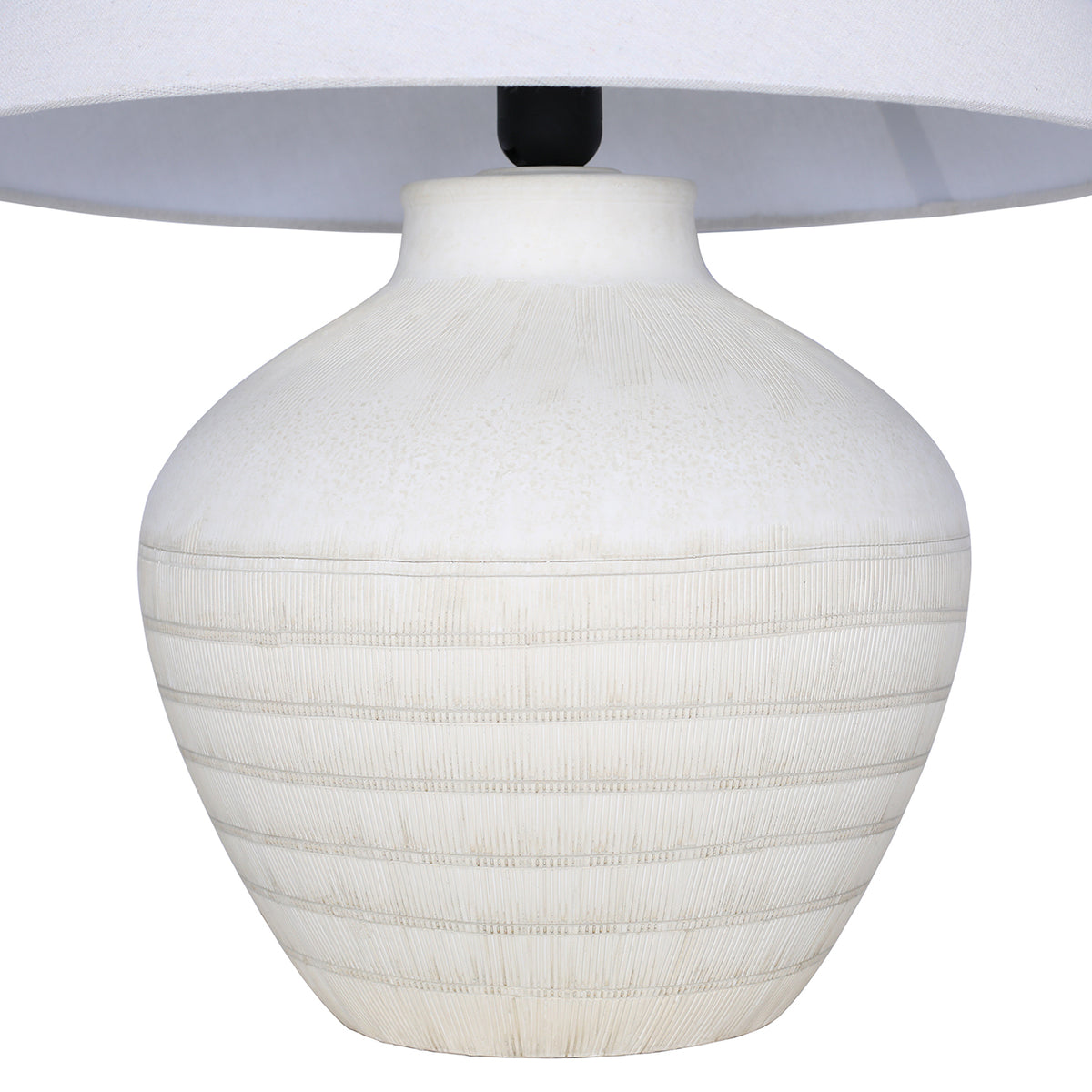 Close view of the rounded white ceramic base, showing fine etched lines at the shoulder and horizontal bands beneath the shade.