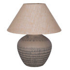 Unlit table lamp with a rounded brown etched ceramic base and wide tapered woven shade on a white background.