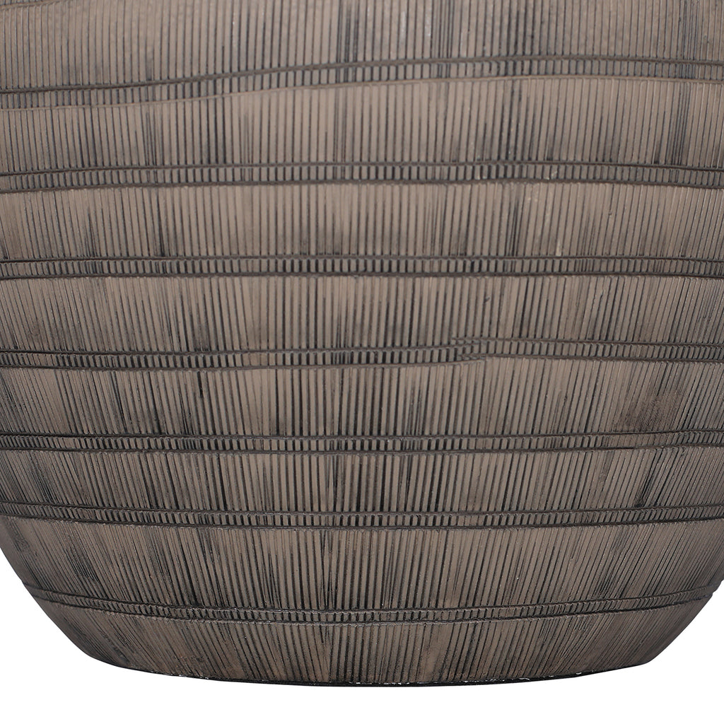 Close-up of the lower brown ceramic base, with narrow horizontal bands crossing closely spaced vertical etched lines.