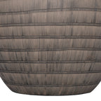 Close-up of the lower brown ceramic base, with narrow horizontal bands crossing closely spaced vertical etched lines.