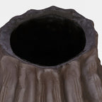 Close view of the vase opening, with an uneven brown rim and dark interior.