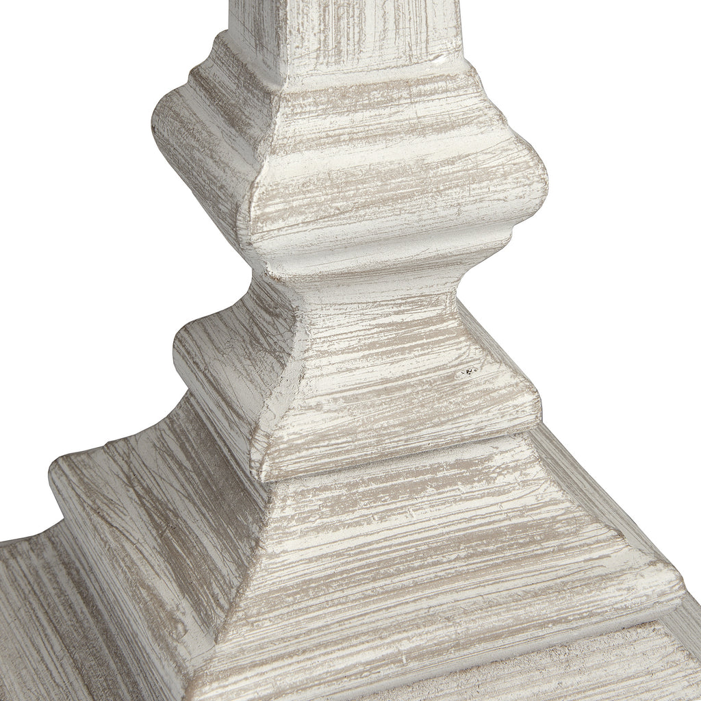 Close-up of the lamp's stepped base, showing fine linear marks and grey-brown tones beneath the pale rubbed-looking finish.
