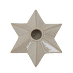 Overhead close-up of the six-point cream star candle holder, with glossy facets radiating from the circular socket.