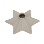 Close angled view into the candle holder's central opening, with warm cream shading along the star's raised ridges.