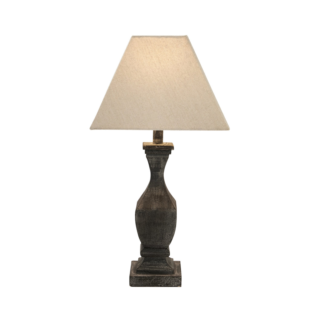 Full table lamp against white, with the pale square shade appearing illuminated above the dark grey-washed base.