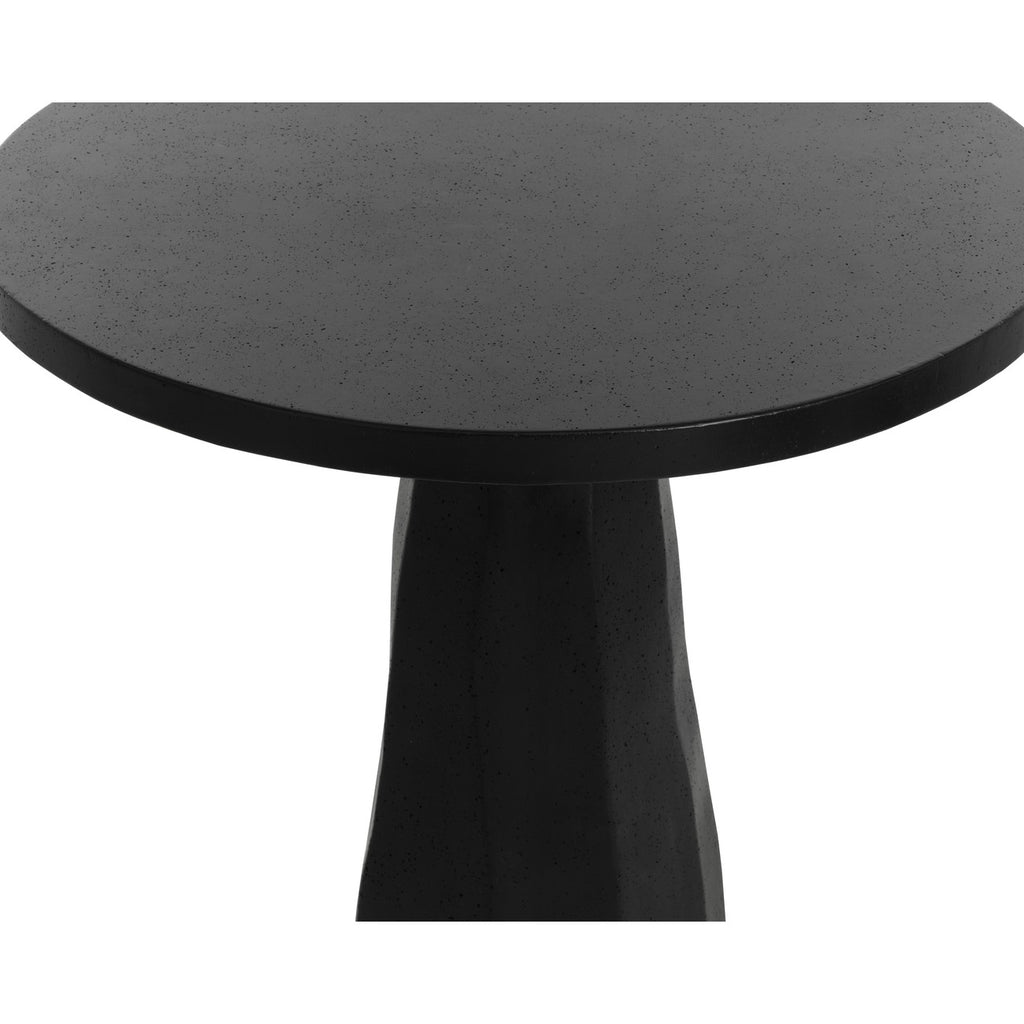 Close-up of the black concrete tabletop, showing small surface pits, the thick edge and upper pedestal.