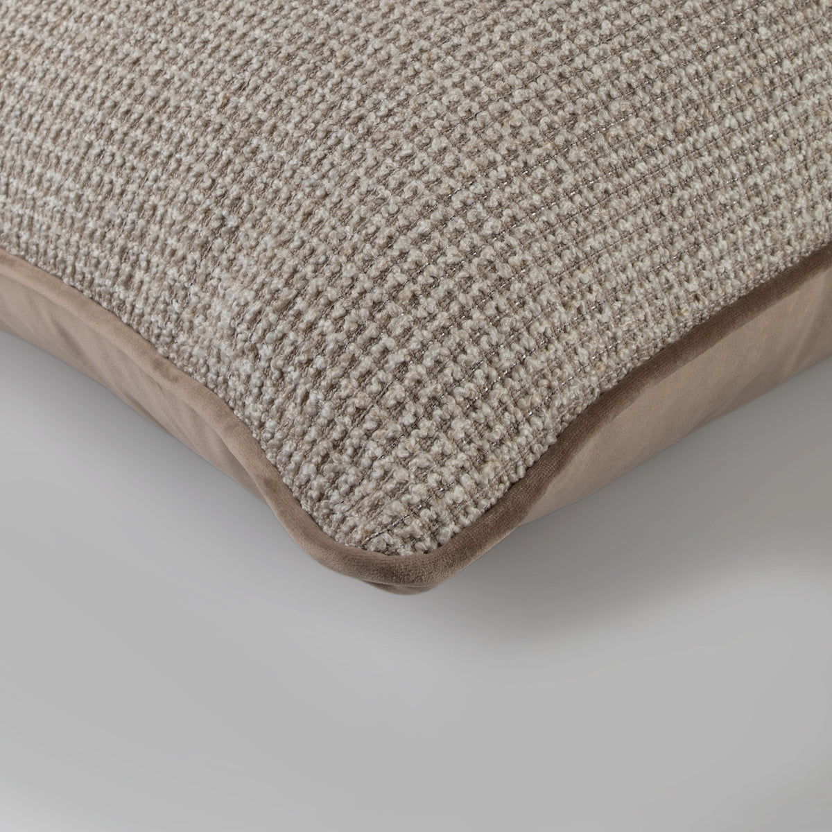 Close-up of the Faro Cushion showing its chunky neutral weave and taupe velvet border