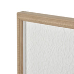Angled detail of the artwork's upper frame corner, showing warm-beige beading beside the rippled white surface.