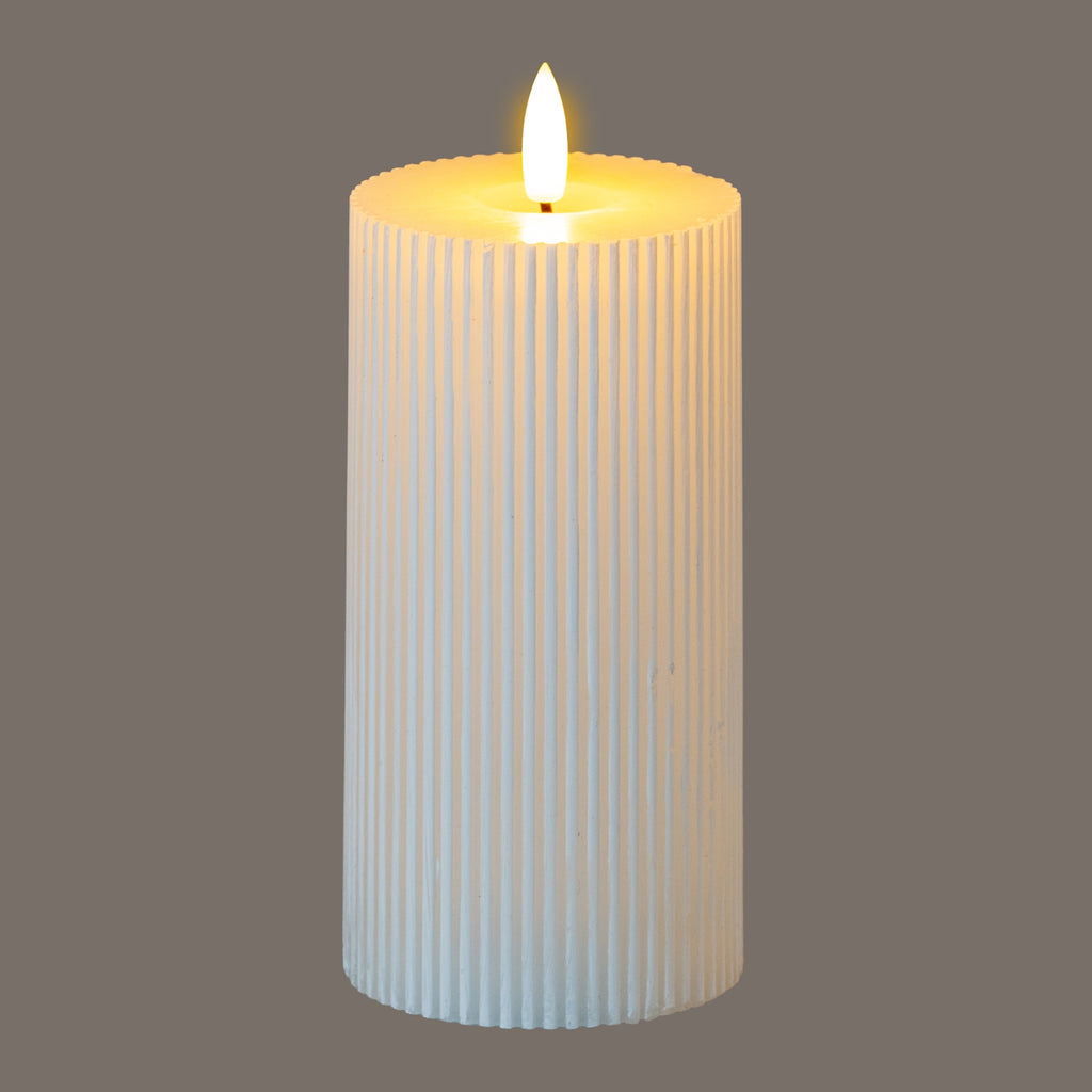 Ribbed LED pillar candle pictured against a grey background, with a bright flame-shaped element and a yellow glow around the recessed top.