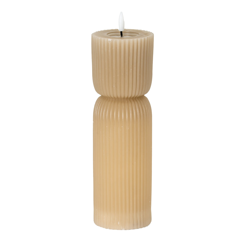 Tall beige LED candle on a white background, with fine vertical ribs, a pinched waist and a white flame-shaped element above a recessed top.